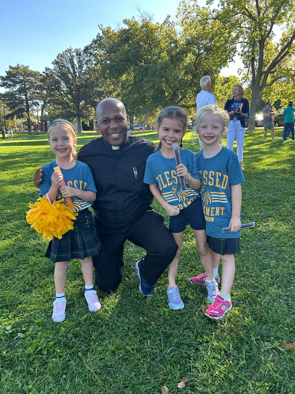 A priest smiling with children at a field day