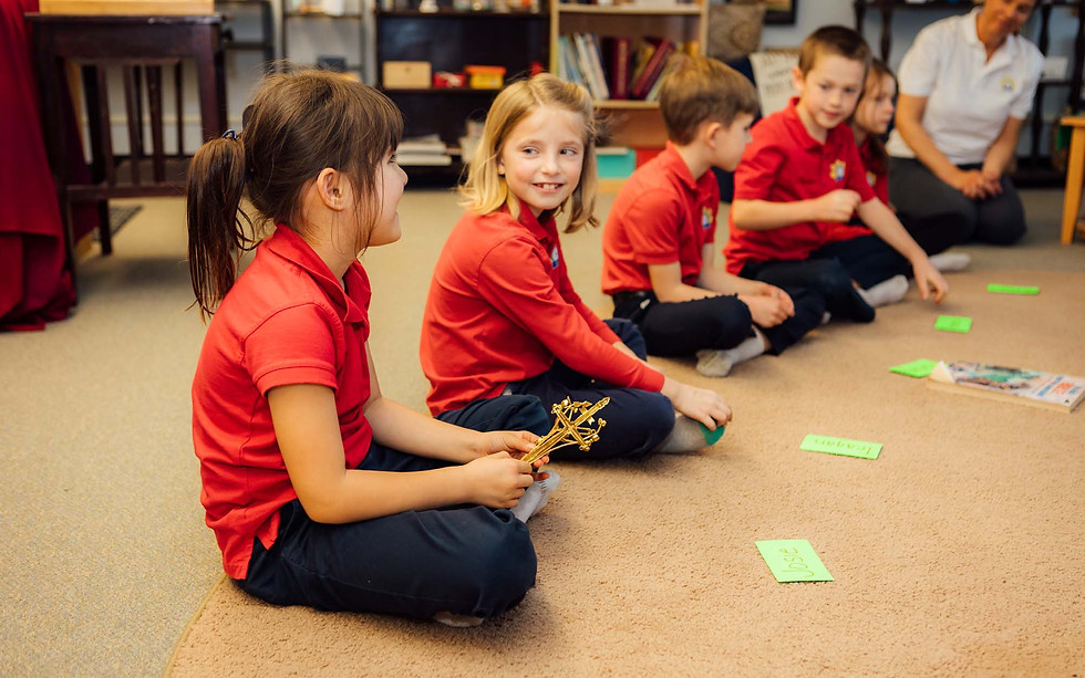 Kids wearing red uniforms sitting in a circle with green notecards in front of them
