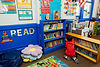 A child getting books from a reading corner in a classroom library